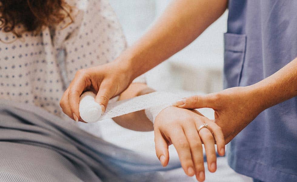 nurse wraps a patient's arm injury after a car accident