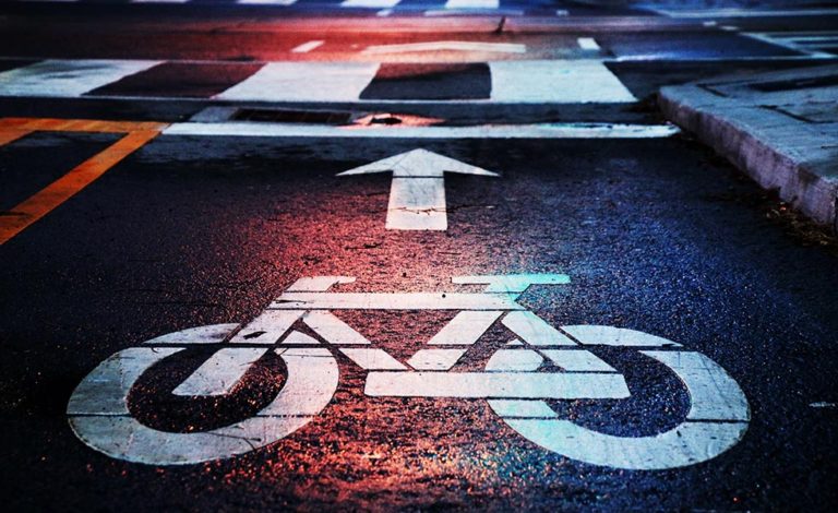 sign for a bike is illuminated red from bicycle accidents