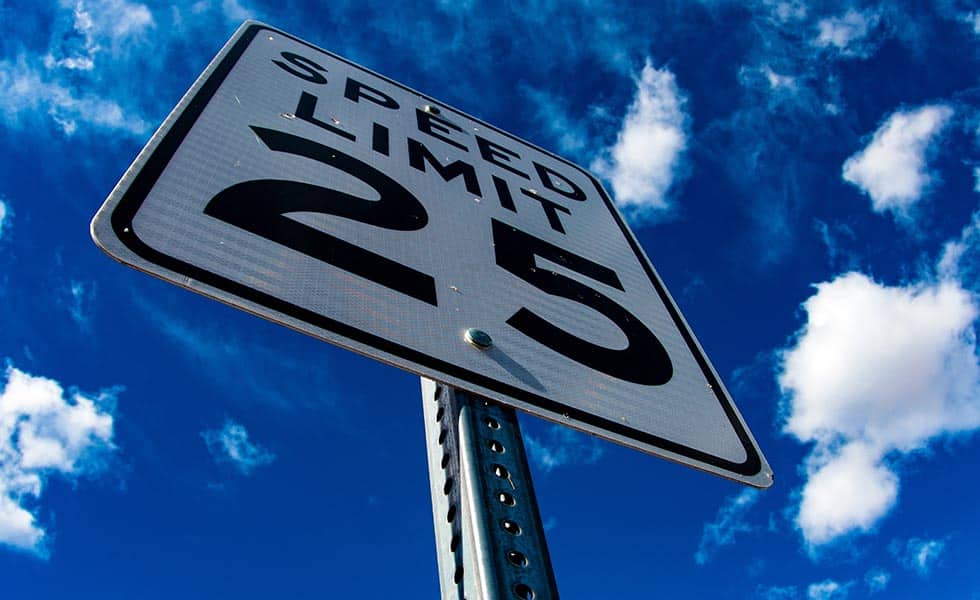 picture of a speed limit sign with a driver avoiding low speed collision injury after a rear-end collision