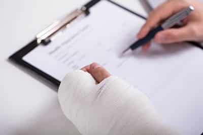 man with a personal injury signs a form for auto accident loans