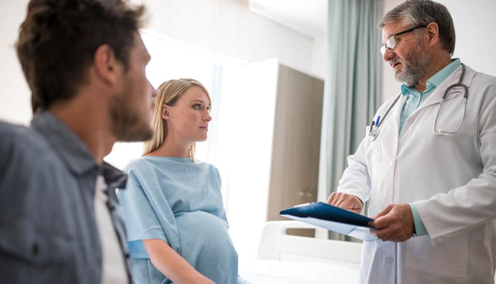 Doctor explaining to a woman she had a miscarriage after a motor accident