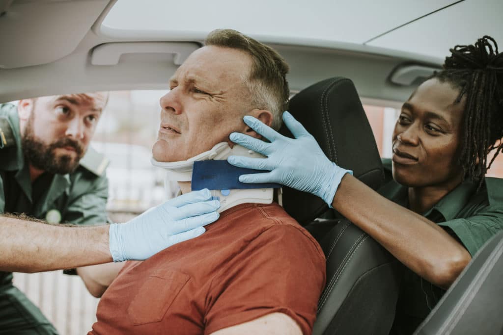 paramedics helping a man with a neck injury