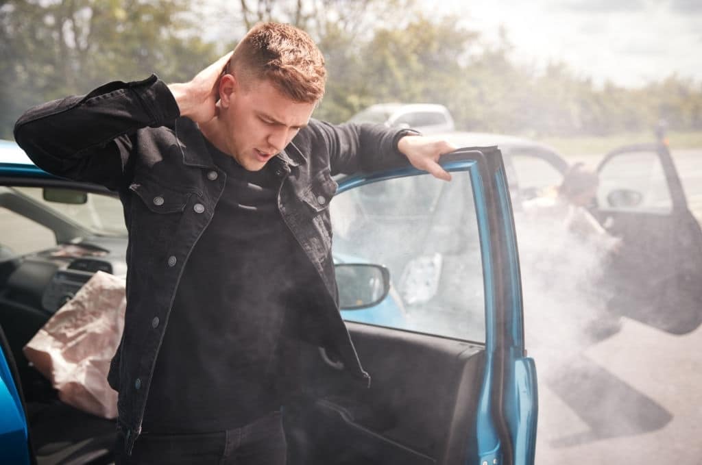 man holds his injured neck after being in a car accident that wasn't your fault